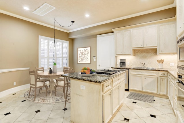 1210 Crocker St, Houston, TX 77019 - kitchen featuring a center island, tasteful backsplash, dark stone countertops, crown molding, and light tile patterned flooring