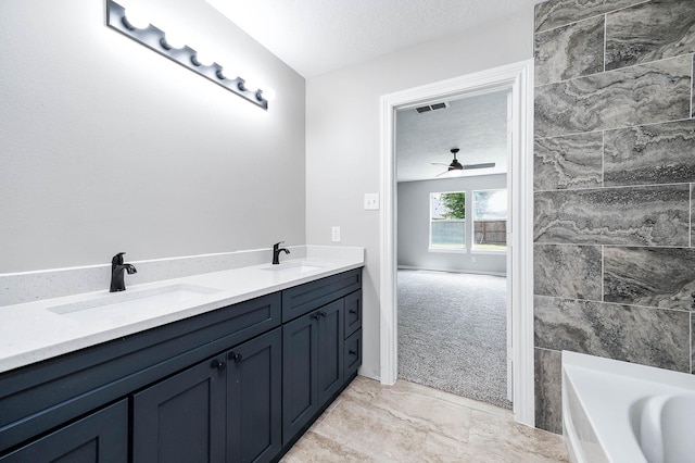 6701 Hidden Colony Ln, League City, TX 77539 - full bath featuring a tub to relax in, a ceiling fan, double vanity, a textured ceiling, and marble look tile flooring