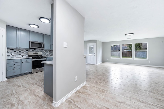 6701 Hidden Colony Ln, League City, TX 77539 - kitchen with appliances with stainless steel finishes, gray cabinetry, open floor plan, light countertops, and tasteful backsplash