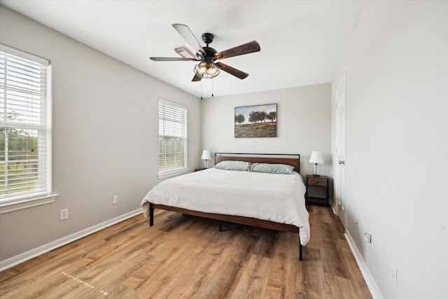 3415 Jack Beaver Rd, Santa Fe, TX 77517 - bedroom with baseboards, light wood-style flooring, and a ceiling fan