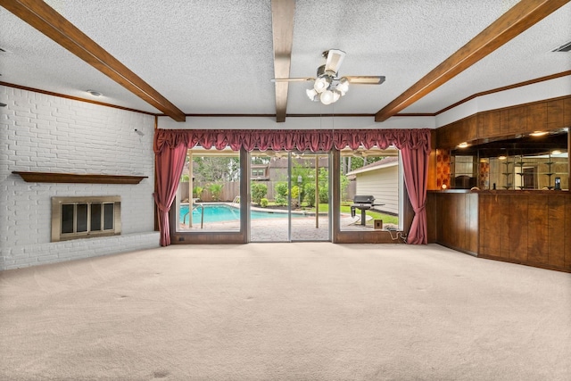 6623 Coral Ridge Rd, Houston, TX 77069 - unfurnished living room featuring carpet flooring, beam ceiling, a textured ceiling, a ceiling fan, and a brick fireplace