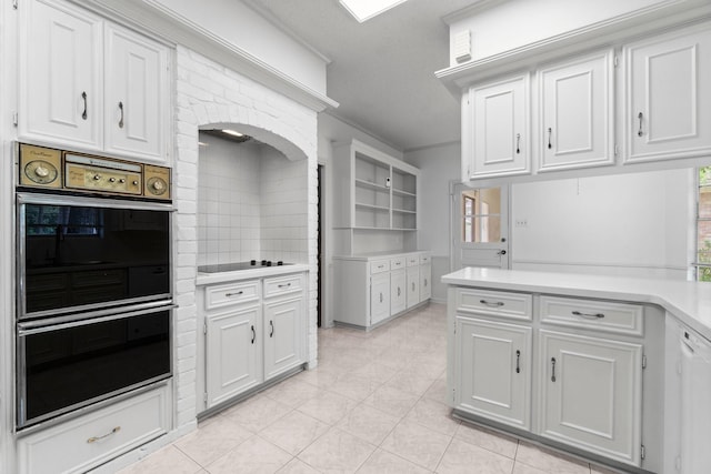 6623 Coral Ridge Rd, Houston, TX 77069 - kitchen with double oven, ornamental molding, light countertops, white cabinetry, and black electric cooktop