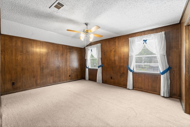 6623 Coral Ridge Rd, Houston, TX 77069 - unfurnished bedroom featuring wood walls, carpet flooring, a textured ceiling, and a ceiling fan
