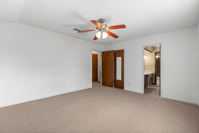 6623 Coral Ridge Rd, Houston, TX 77069 - unfurnished bedroom featuring light carpet, baseboards, ensuite bath, a ceiling fan, and a textured ceiling
