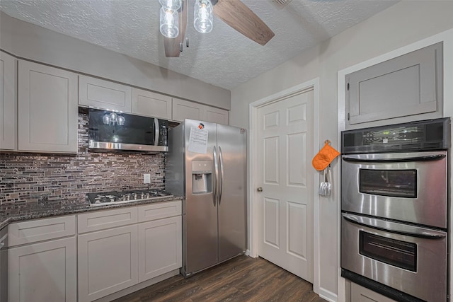 15726 Blackhawk Blvd, Friendswood, TX 77546 - kitchen with appliances with stainless steel finishes, dark wood-style flooring, tasteful backsplash, stone counters, and a textured ceiling