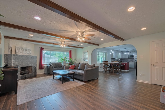 15726 Blackhawk Blvd, Friendswood, TX 77546 - living area featuring a textured ceiling, arched walkways, ceiling fan, beamed ceiling, and dark wood-style floors
