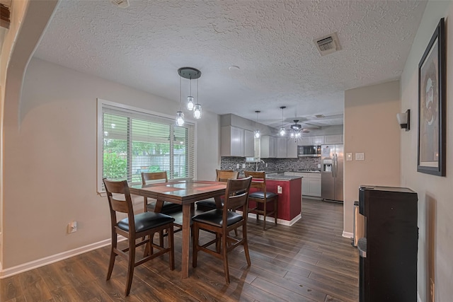 15726 Blackhawk Blvd, Friendswood, TX 77546 - dining area featuring dark wood-type flooring, a ceiling fan, a textured ceiling, and baseboards