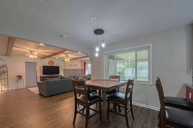 15726 Blackhawk Blvd, Friendswood, TX 77546 - dining room featuring ceiling fan, dark wood-type flooring, arched walkways, baseboards, and a textured ceiling