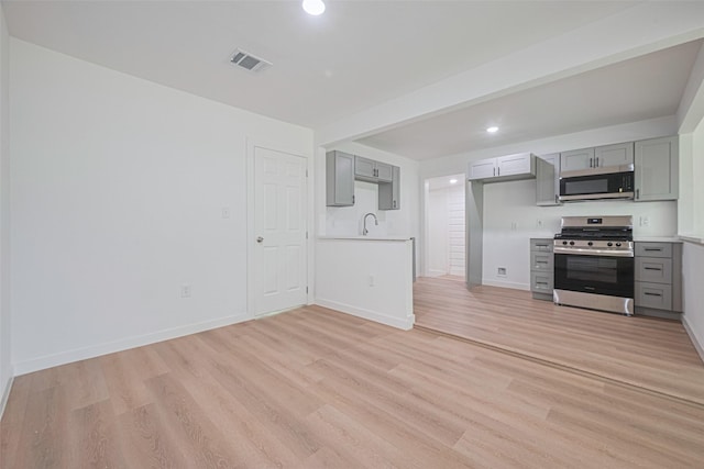 606 Cresline St, Houston, TX 77076 - kitchen with appliances with stainless steel finishes, gray cabinets, light countertops, light wood finished floors, and recessed lighting