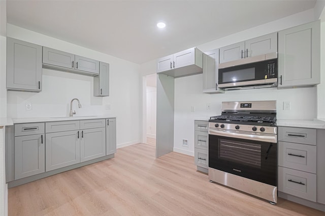 606 Cresline St, Houston, TX 77076 - kitchen with stainless steel appliances, gray cabinetry, light wood-style floors, light countertops, and recessed lighting