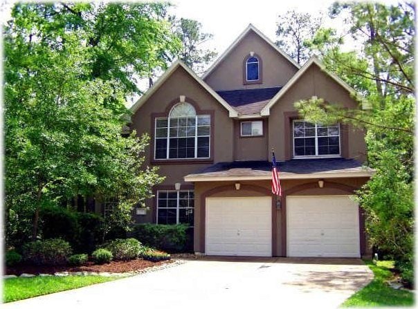 3 Candle Pine Pl, The Woodlands, TX 77381 - traditional home with stucco siding, a garage, and driveway