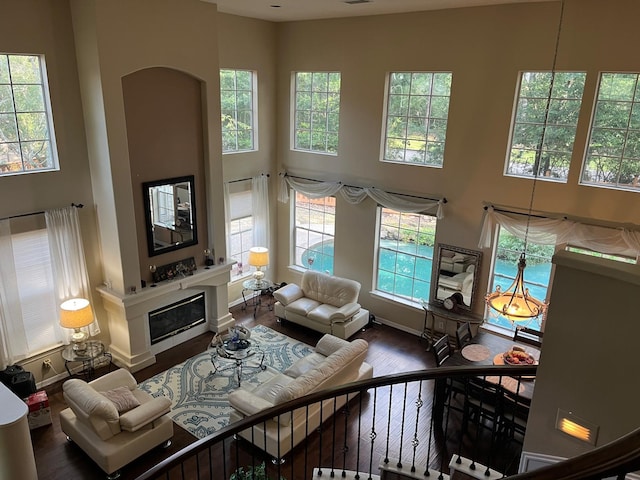 3 Candle Pine Pl, The Woodlands, TX 77381 - living area featuring a high ceiling, wood finished floors, plenty of natural light, baseboards, and a glass covered fireplace