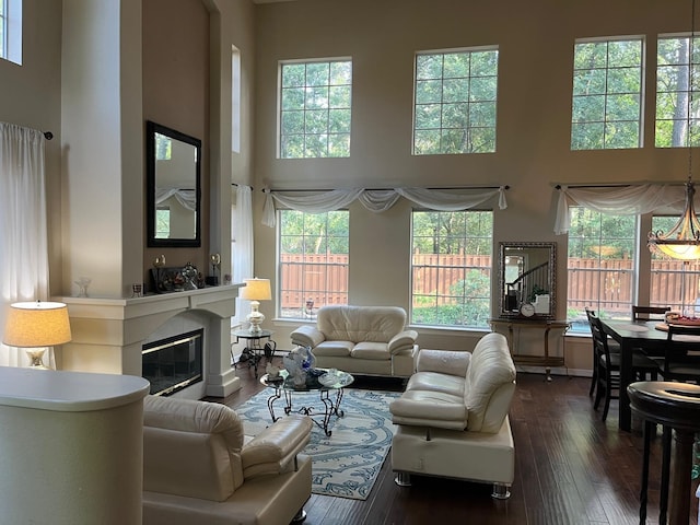 3 Candle Pine Pl, The Woodlands, TX 77381 - living area featuring a high ceiling, dark wood-type flooring, a glass covered fireplace, and baseboards