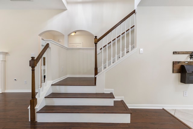 38 Florian Ct, Conroe, TX 77385 - stairs featuring wood-type flooring, arched walkways, and baseboards