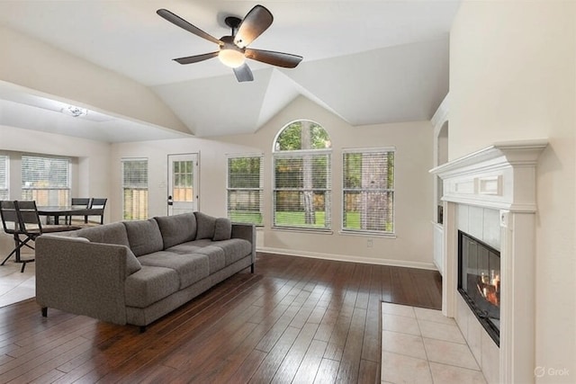 38 Florian Ct, Conroe, TX 77385 - living area with a ceiling fan, light wood finished floors, a tiled fireplace, vaulted ceiling, and baseboards