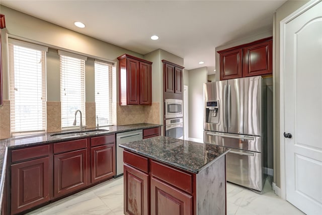 17215 Astrachan Rd, Richmond, TX 77407 - kitchen featuring stainless steel appliances, a sink, reddish brown cabinets, light marble finish floors, and recessed lighting