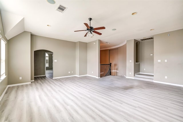 17215 Astrachan Rd, Richmond, TX 77407 - unfurnished living room with arched walkways, ceiling fan, light wood-style floors, baseboards, and recessed lighting