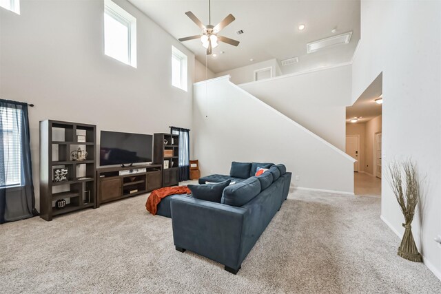 3607 Crosspointe Pass, Angleton, TX 77515 - carpeted living area featuring a ceiling fan, a high ceiling, stairs, and baseboards