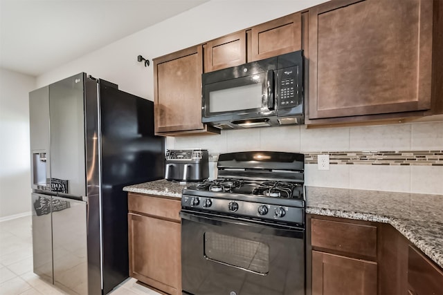 3607 Crosspointe Pass, Angleton, TX 77515 - kitchen featuring black appliances, light stone countertops, decorative backsplash, and baseboards