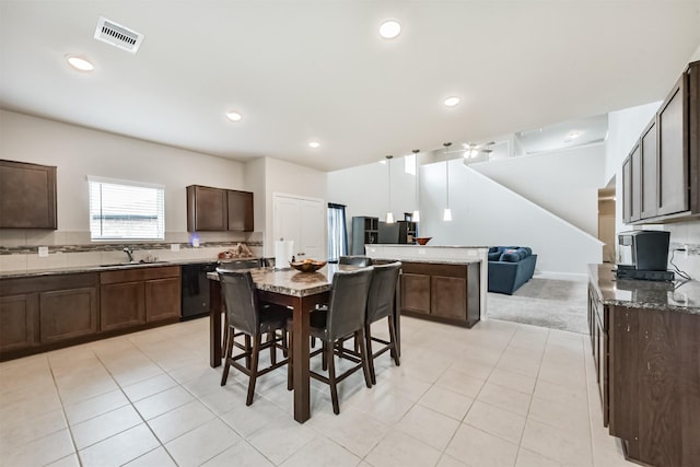 3607 Crosspointe Pass, Angleton, TX 77515 - kitchen featuring dark brown cabinetry, a sink, black dishwasher, dark stone counters, and open floor plan