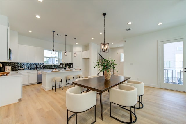 4043 Buck St, Houston, TX 77020 - dining area featuring light wood-style flooring, recessed lighting, a chandelier, and stairway