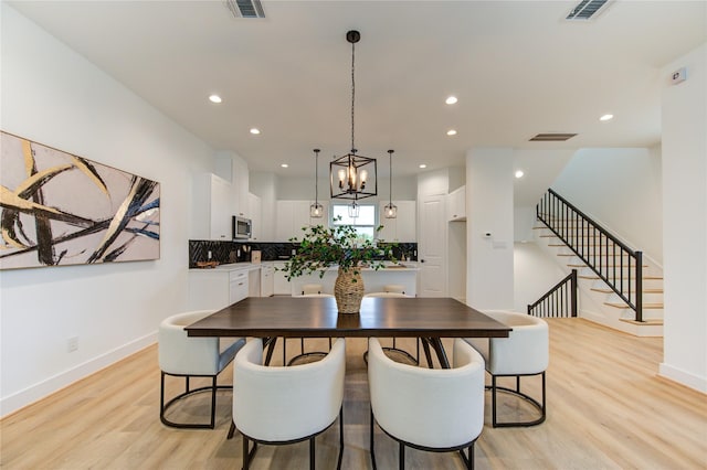 4043 Buck St, Houston, TX 77020 - dining room with light wood-type flooring, baseboards, stairway, recessed lighting, and a chandelier
