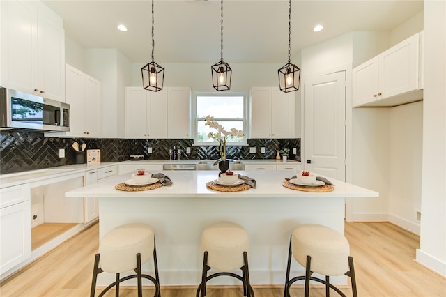 4043 Buck St, Houston, TX 77020 - kitchen with appliances with stainless steel finishes, a breakfast bar, tasteful backsplash, white cabinetry, and recessed lighting