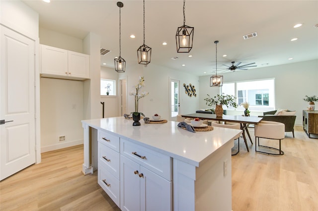 4043 Buck St, Houston, TX 77020 - kitchen featuring a center island, recessed lighting, light wood-type flooring, white cabinets, and a ceiling fan