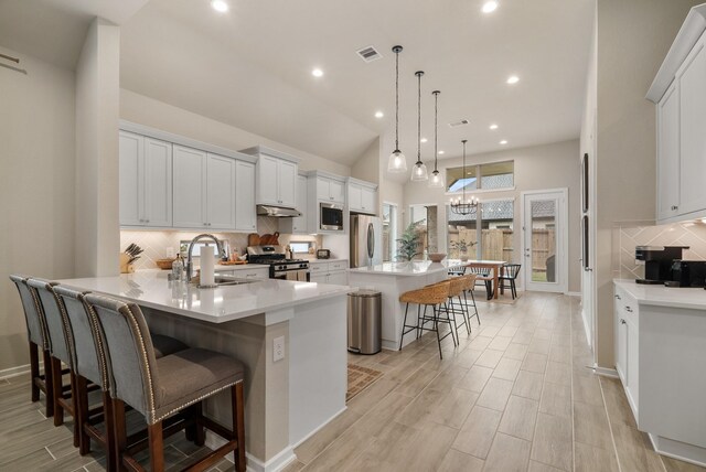 29639 Mahogany View Ln, Fulshear, TX 77441 - kitchen featuring a sink, stainless steel appliances, a kitchen bar, tasteful backsplash, and a peninsula