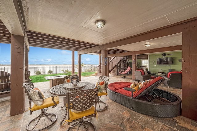 792 W Bayshore Dr, Palacios, TX 77465 - fenced backyard with a patio area, a water view, outdoor dining area, stairway, and an outdoor hangout area