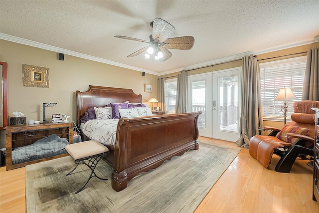 792 W Bayshore Dr, Palacios, TX 77465 - bedroom featuring access to outside, crown molding, wood finished floors, a textured ceiling, and french doors