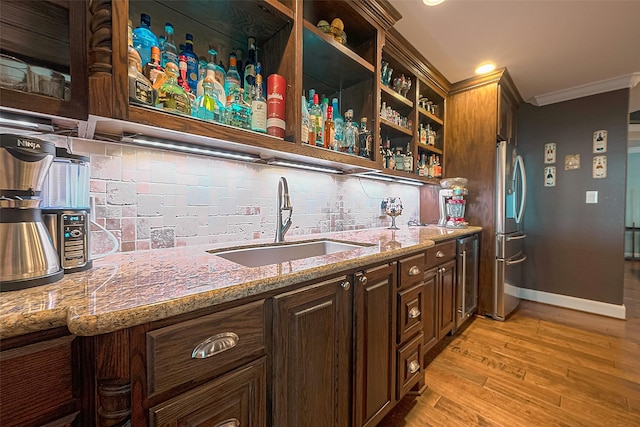 792 W Bayshore Dr, Palacios, TX 77465 - bar featuring a sink, freestanding refrigerator, crown molding, light wood-style floors, and baseboards