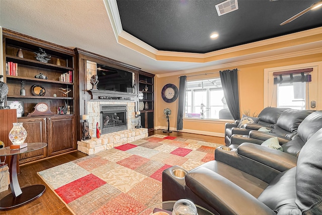 792 W Bayshore Dr, Palacios, TX 77465 - living area with ornamental molding, wood finished floors, plenty of natural light, a stone fireplace, and a raised ceiling