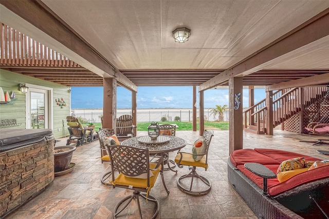 792 W Bayshore Dr, Palacios, TX 77465 - fenced backyard with outdoor dining space, a patio, stairs, and a water view