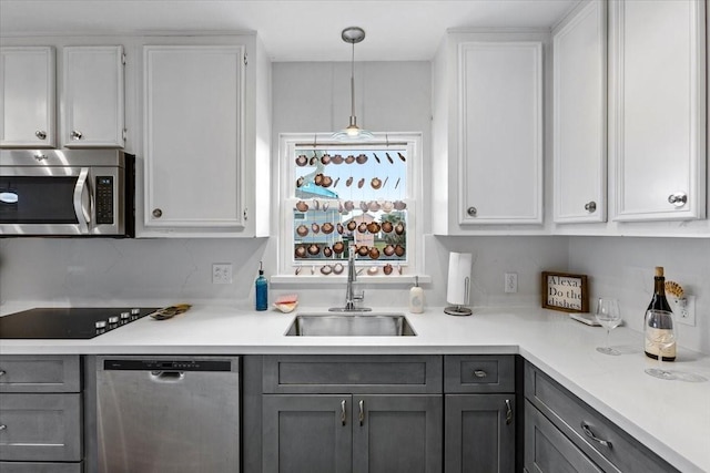 4220 Las Palmas St, Galveston, TX 77554 - kitchen with appliances with stainless steel finishes, gray cabinets, light countertops, and white cabinets