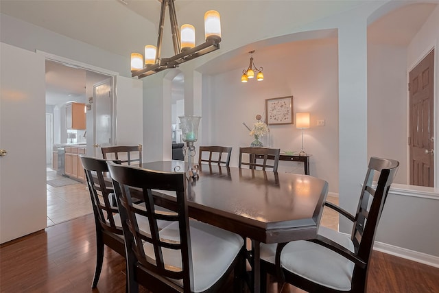 11826 Balmorhea Ln, Sugar Land, TX 77498 - dining room featuring a chandelier, wood finished floors, and arched walkways