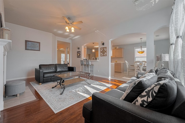 11826 Balmorhea Ln, Sugar Land, TX 77498 - living room with arched walkways, ceiling fan, light wood-style flooring, and baseboards