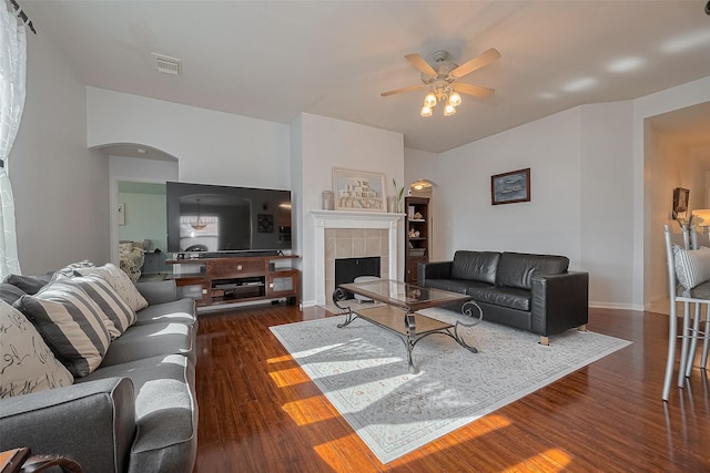 11826 Balmorhea Ln, Sugar Land, TX 77498 - living room with a ceiling fan, wood finished floors, a tile fireplace, arched walkways, and baseboards