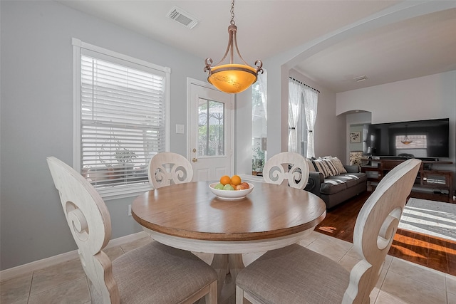 11826 Balmorhea Ln, Sugar Land, TX 77498 - dining room with arched walkways, light tile patterned flooring, and baseboards