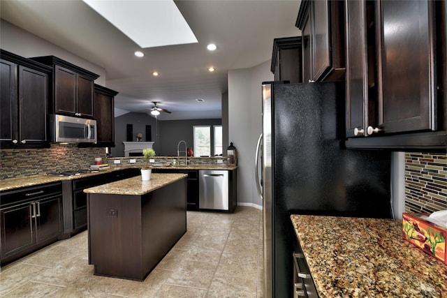 24302 Marisa Ln, Richmond, TX 77406 - kitchen featuring stainless steel appliances, recessed lighting, decorative backsplash, a skylight, and light stone countertops
