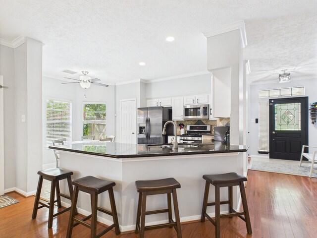 3707 Scenic Valley Dr, Kingwood, TX 77345 - kitchen featuring appliances with stainless steel finishes, dark countertops, a sink, a peninsula, and a textured ceiling
