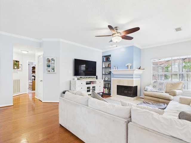 3707 Scenic Valley Dr, Kingwood, TX 77345 - living room featuring a ceiling fan, wood finished floors, a fireplace, crown molding, and built in features