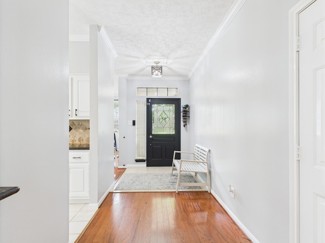 3707 Scenic Valley Dr, Kingwood, TX 77345 - foyer with light wood-type flooring, a textured ceiling, ornamental molding, and baseboards