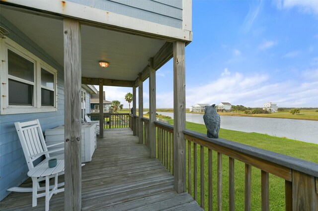 4003 Indian Beach Dr, Galveston, TX 77554 - wooden porch featuring a water view and a lawn