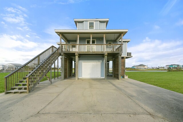 4003 Indian Beach Dr, Galveston, TX 77554 - beach home with stairs, a garage, a porch, a front lawn, and concrete driveway
