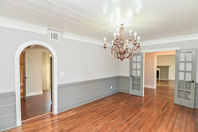 1031 Meyer St, Sealy, TX 77474 - empty room featuring arched walkways, wood finished floors, ornamental molding, a chandelier, and french doors