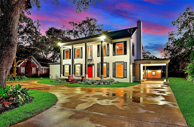1031 Meyer St, Sealy, TX 77474 - view of front of home featuring curved driveway, a chimney, a carport, and a front lawn