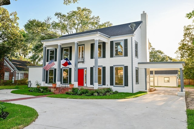 1031 Meyer St, Sealy, TX 77474 - greek revival house featuring driveway, a chimney, and an attached carport