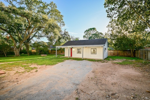 1031 Meyer St, Sealy, TX 77474 - view of front facade with a fenced backyard, asphalt driveway, and an outbuilding