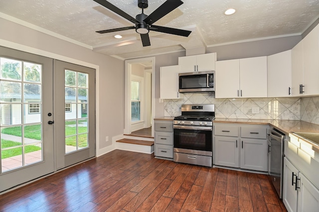 1031 Meyer St, Sealy, TX 77474 - kitchen with stainless steel appliances, dark wood-style floors, a textured ceiling, decorative backsplash, and light countertops